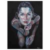 A captivating Contemporary Acrylic art painting titled 'Reflections of Self' depicts a woman seated in water against a black canvas backdrop. Her slicked-back hair and intense blue eyes draw attention, while vibrant turquoise and terracotta reds accentuate her skin tone. She rests her chin on her hand, evoking introspection and contemplation."